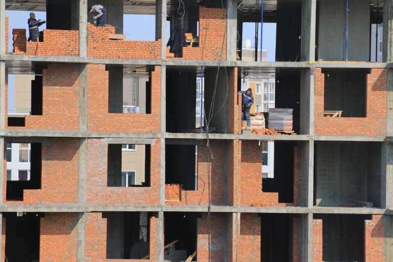 Mehrgeschossiger Rohbau aus rotem Ziegelmauerwerk mit ausgesparten Fensteröffnungen